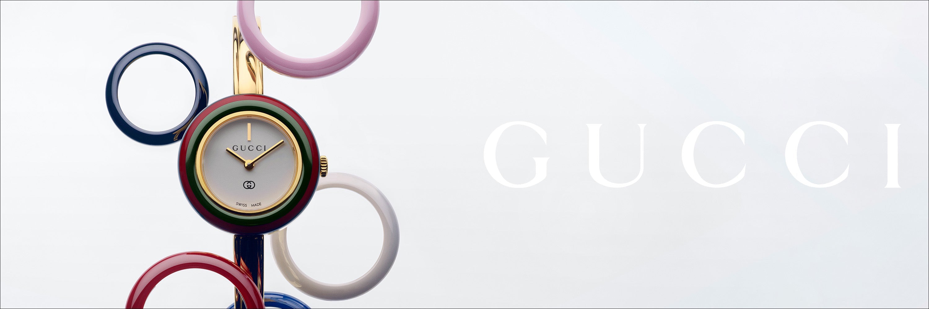Eine elegante silberne Gucci-Armbanduhr mit schwarzem Zifferblatt und Metallarmband auf weißem Hintergrund. Auf der rechten Seite sind das Gucci-Logo und das Wort „Uhren“ abgebildet.