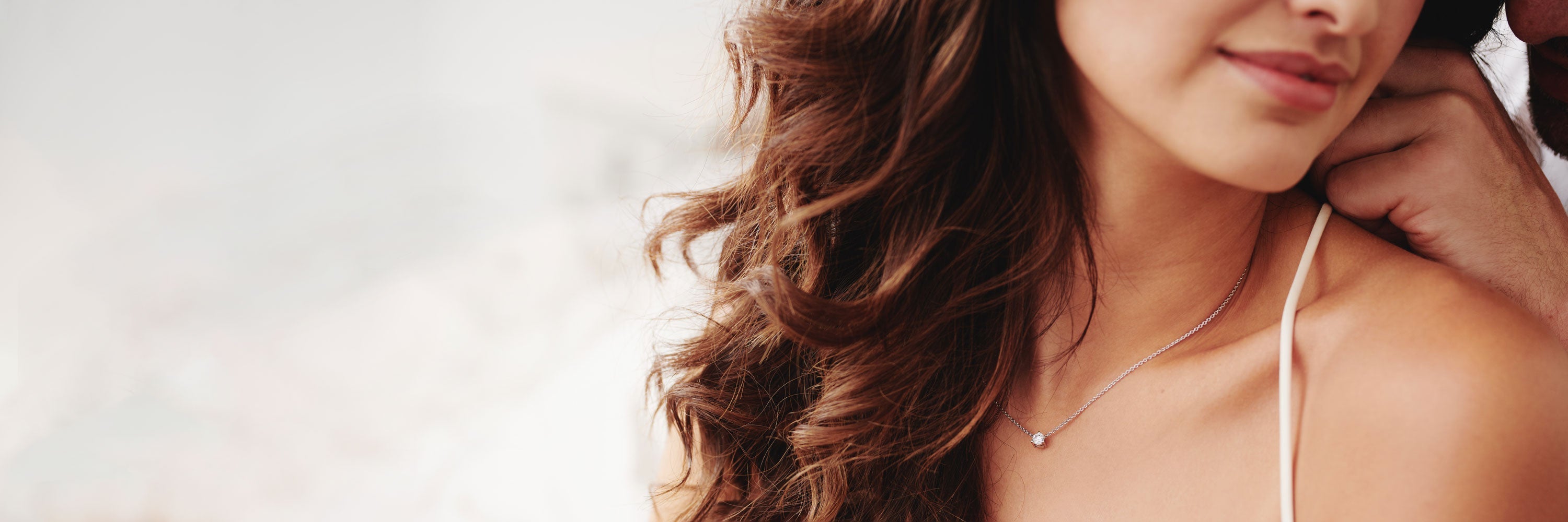 Dame in schwarzem Oberteil trägt eine Halskette der Kollektion Solitaire, die sich durch ihren feinen Schliff hervorhebt.