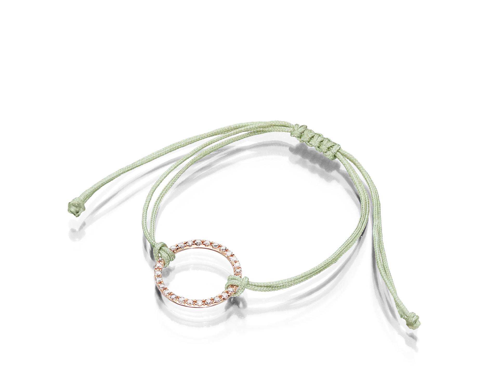 Das DIAMANT ARMBAND von Schullin ist in einem hellgrünen Farbton gestaltet, hat einen verstellbaren Knoten und einen roségoldenen Diamantkreis in der Mitte, der mit kleinen funkelnden Steinen geschmückt ist. Dieses Armband hat außerdem zwei lose Enden, um eine perfekte Passform zu gewährleisten.