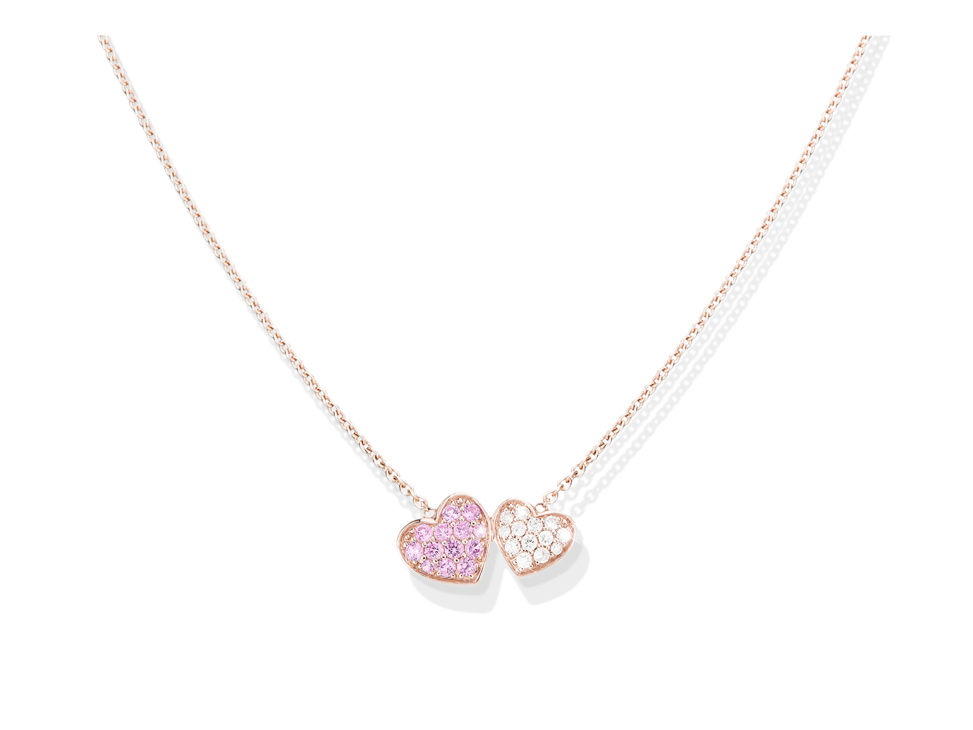 Die HERZEN HALSKETTE von Schullin besteht aus zwei herzförmigen Anhängern - einer mit rosafarbenen Steinen, der andere mit klaren Steinen - die an einer zarten Roségoldkette hängen.