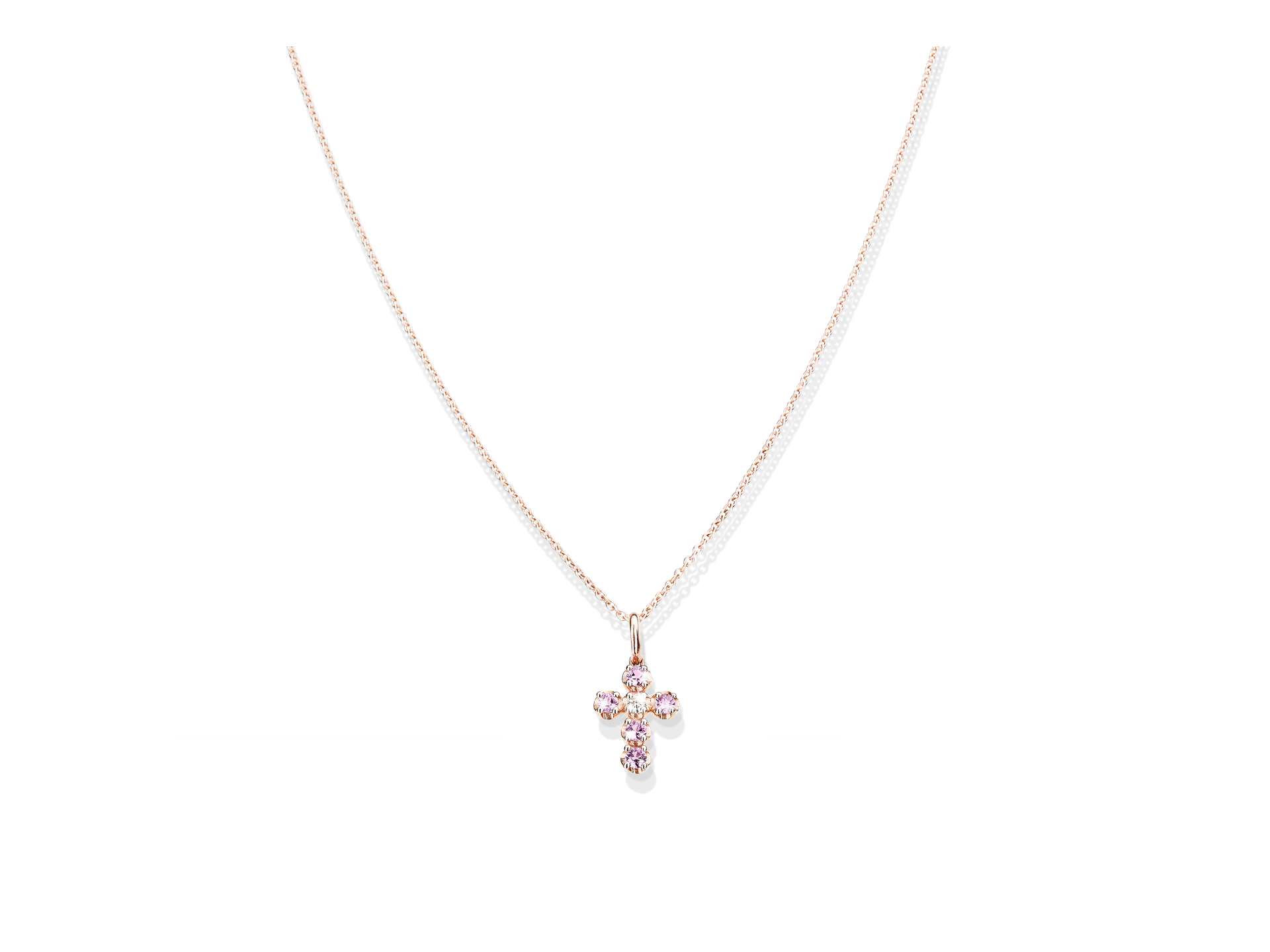 Die SAPHIR HALSKETTE KREUZ von Schullin ist eine zarte Goldkette mit einem kleinen, mit rosafarbenen Edelsteinen besetzten Kreuzanhänger, der auf weißem Hintergrund abgebildet ist.