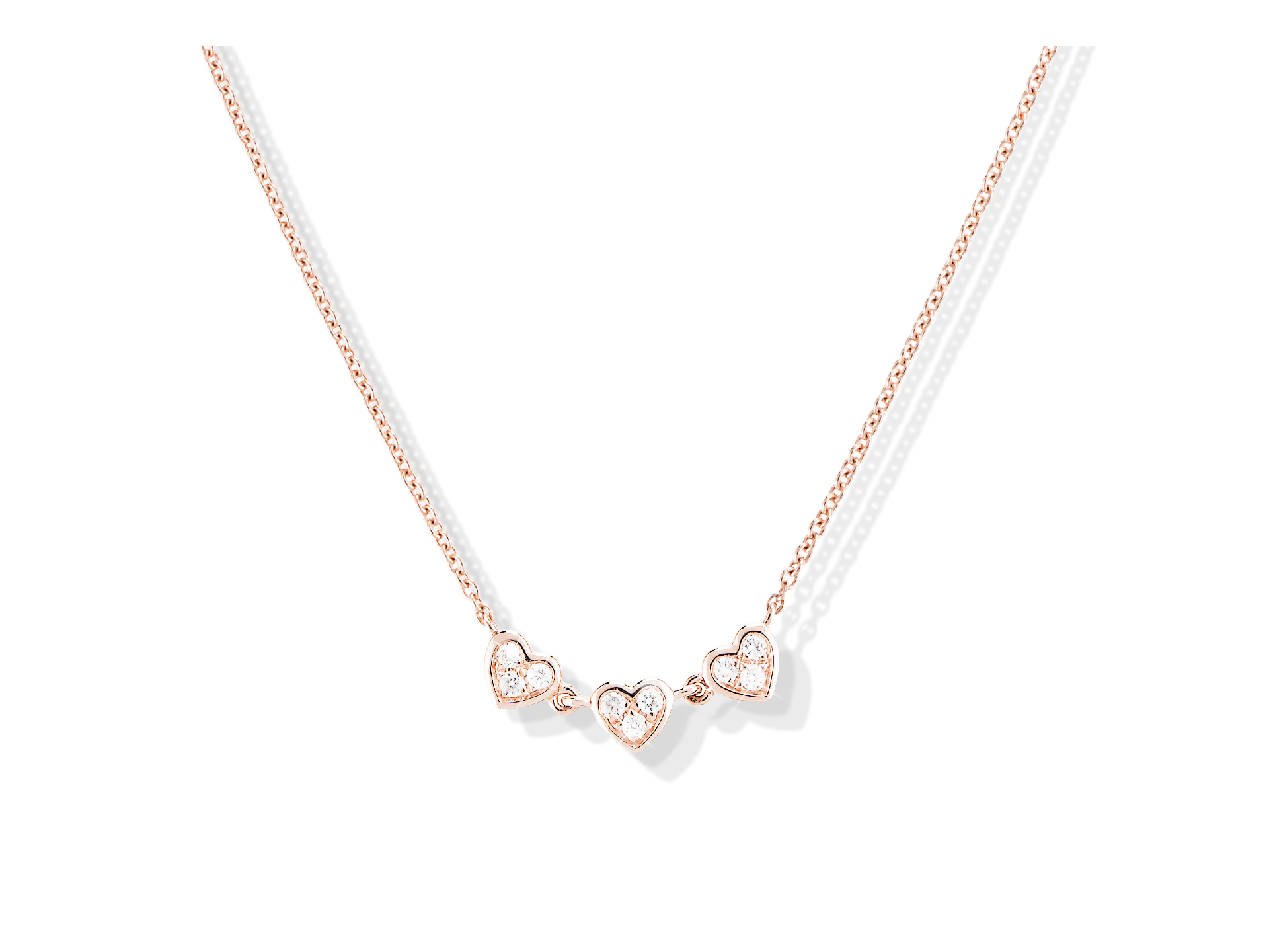 Das Collier DIAMANT HALSKETTE HEARTS von Schullin ist ein Collier aus Roségold mit drei herzförmigen Anhängern, die jeweils mit einem Diamanten in der Mitte besetzt sind und vor einem schlichten weißen Hintergrund stehen.