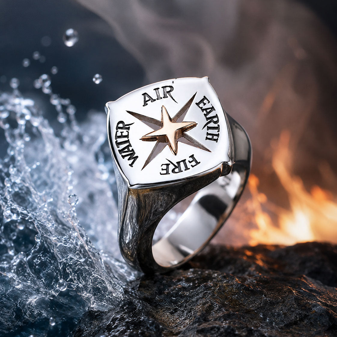 Der ELEMENTS RING SILBER von Schullin zeigt ein erhabenes Kompassmotiv mit den Gravuren AIR, EARTH, FIRE und WATER um einen zentralen Stern. Er wird auf einem Felsen inmitten von spritzendem Wasser und loderndem Feuer präsentiert.