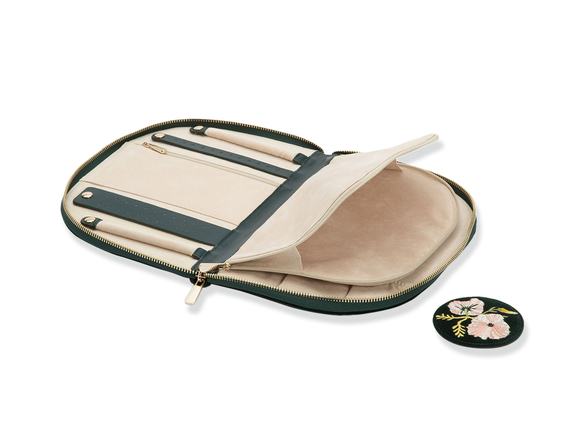 Eine aufgeschlagene beige und dunkelgrüne SCHMUCKTASCHE von Schullin zeigt Fächer für Stifte und ein Notizbuch, daneben liegt eine runde schwarze, mit rosa Blumen bestickte Schullin-Dose.