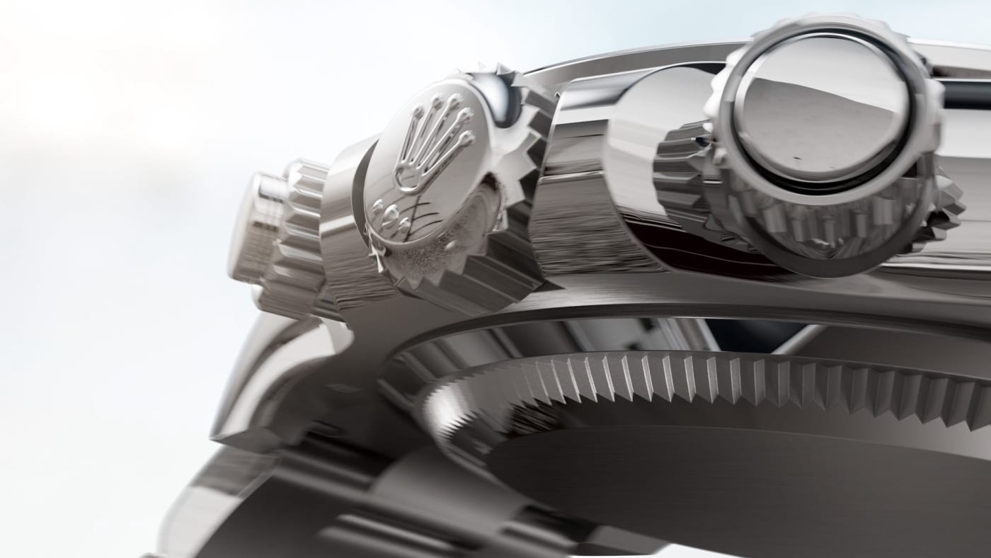 Nahaufnahme einer Luxusuhr, die die Seitenansicht des Gehäuses mit poliertem Metallfinish zeigt. Das aufwendige Design umfasst zwei markante Kronen und ein Logo auf einer Krone, was die detaillierte Handwerkskunst und Präzisionstechnik hervorhebt.
