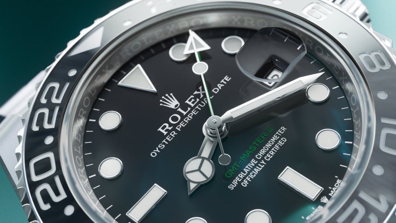 Nahaufnahme eines Rolex Oyster Perpetual Date-Zifferblatts mit schwarzem Zifferblatt und leuchtenden Stundenmarkierungen und Zeigern. Die Uhr verfügt über eine drehbare Lünette mit silber-schwarzem Design und der Markenname ist deutlich sichtbar.