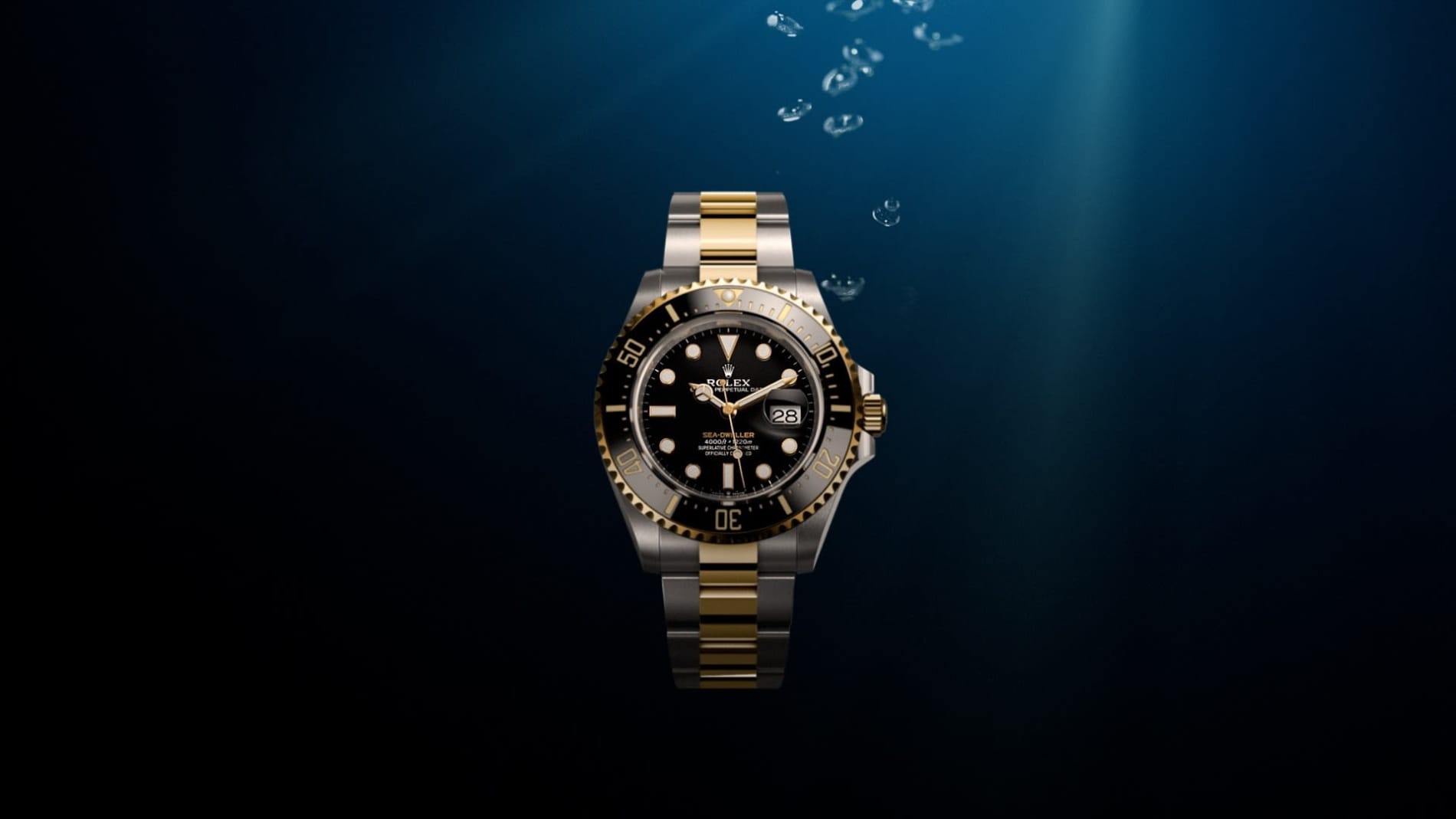 Eine Luxusarmbanduhr mit zweifarbigem Gold- und Silberarmband, schwarzem Zifferblatt und goldverzierter Lünette wird in Wasser getaucht. Blasen steigen an die Oberfläche und Licht dringt von oben ein, was einen dramatischen Effekt erzeugt.