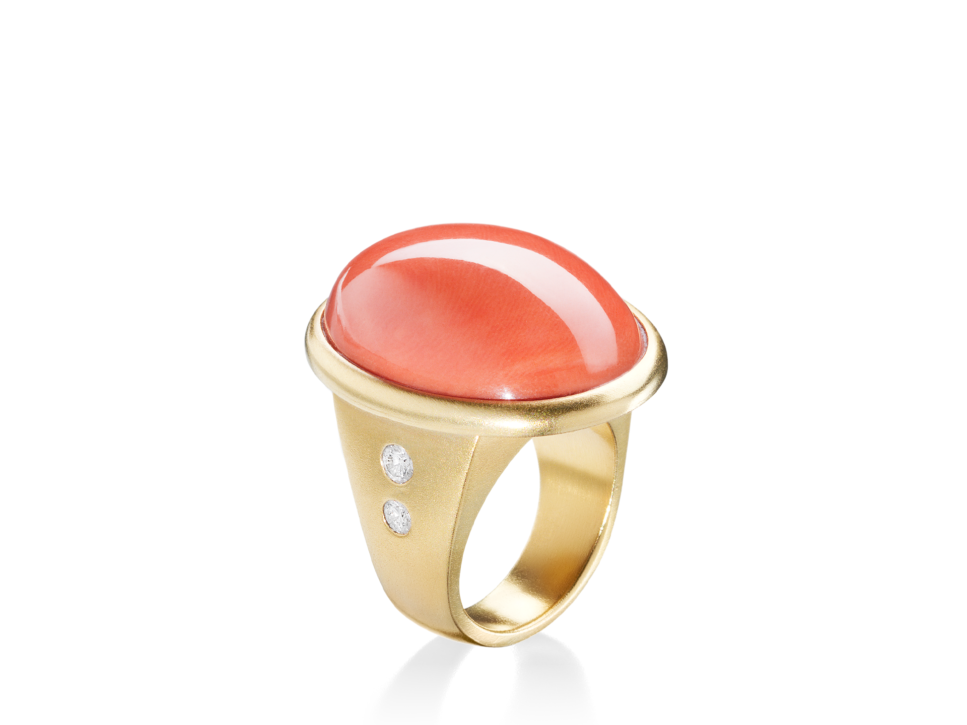 Wir präsentieren den KORALLENRING von Schullin, ein atemberaubendes Stück aus Gelbgold mit einem markanten, glatten, ovalen Mittelstück aus roter Koralle, das auf jeder Seite des Rings mit zwei kleinen, runden Diamanten verziert ist.