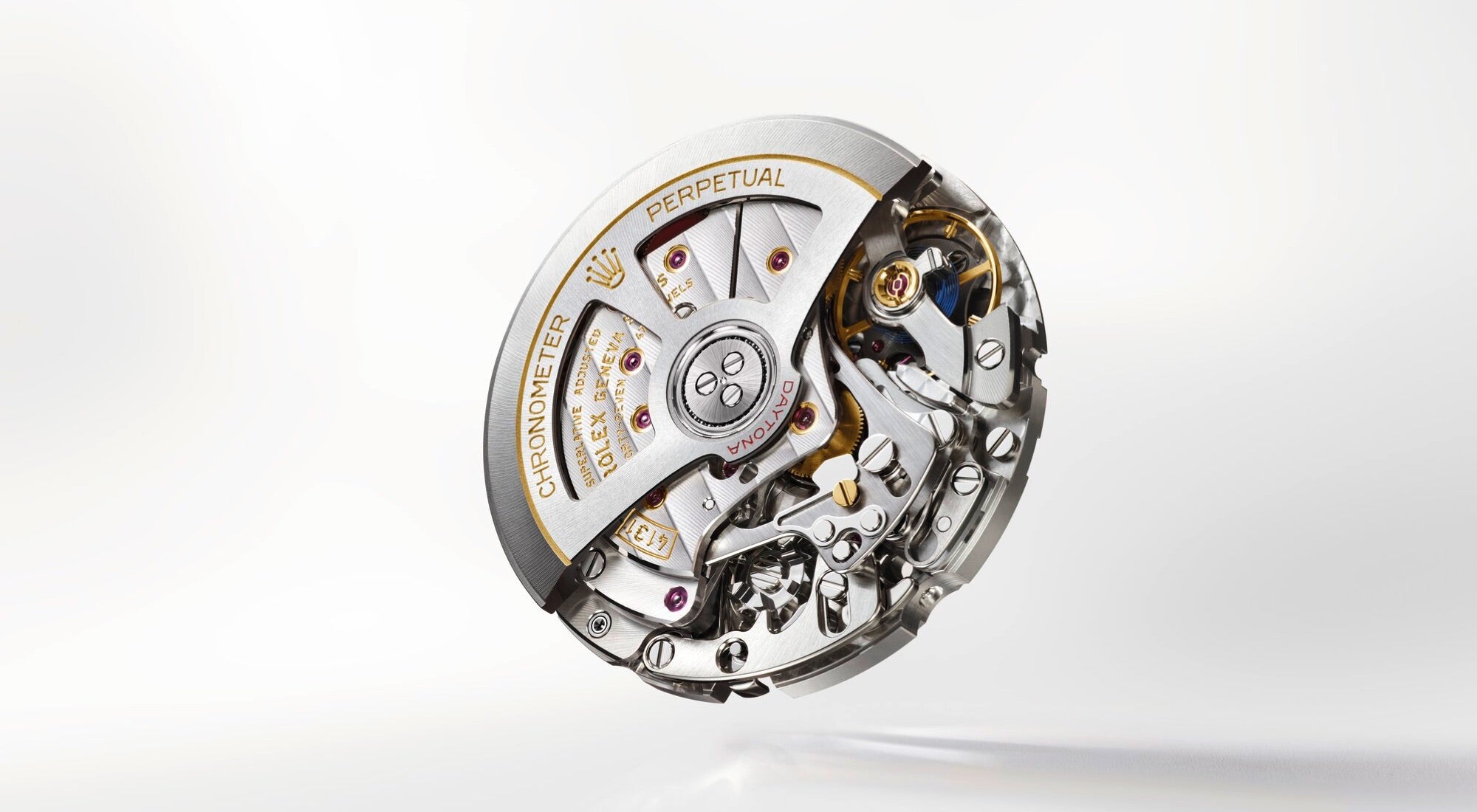 Nahaufnahme eines Uhrwerkmechanismus mit komplizierten Zahnrädern, Schrauben und Metallkomponenten. Der Text „CHRONOMETER PERPETUAL“ ist sichtbar, zusammen mit einem kleinen Logo. Der Mechanismus weist eine Mischung aus Silber- und Goldtönen auf.