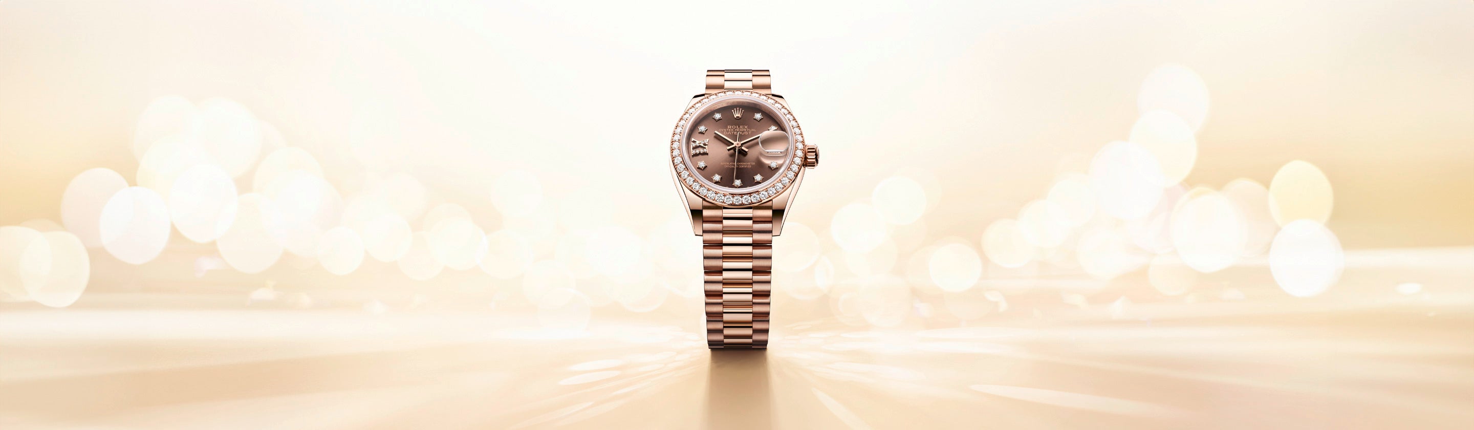 Eine Luxusarmbanduhr mit einem Armband aus Gold- und Silbermetall steht zentriert vor einem weichen, leuchtenden Hintergrund. Die Uhr hat ein rundes Zifferblatt, eine diamantbesetzte Lünette und feine Stundenmarkierungen.