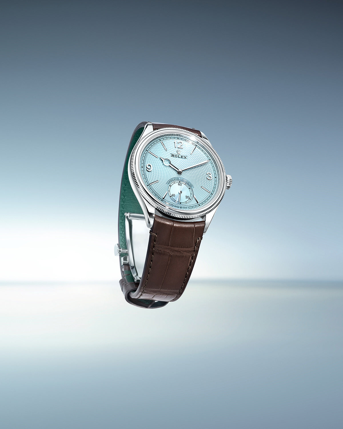 Eine luxuriöse Armbanduhr mit hellblauem Zifferblatt und silbernen Details. Sie verfügt über ein braunes Lederarmband und eine silberne Lünette. Der Hintergrund ist ein Farbverlauf von Hellgrau nach Blau.