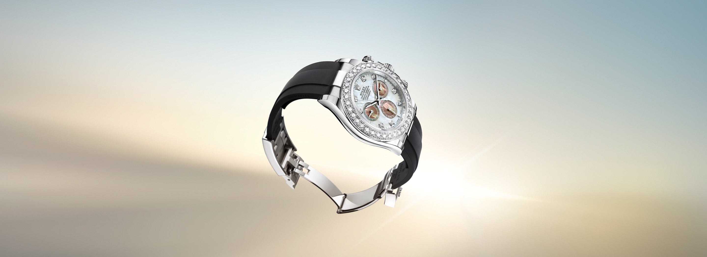 Eine Luxusarmbanduhr mit schwarzem Armband und silberner Lünette, die vor einem Hintergrund mit Farbverlauf frei schwebt. Das Zifferblatt verfügt über mehrere Hilfszifferblätter und reflektiert das Sonnenlicht, wodurch ein strahlender Effekt entsteht.