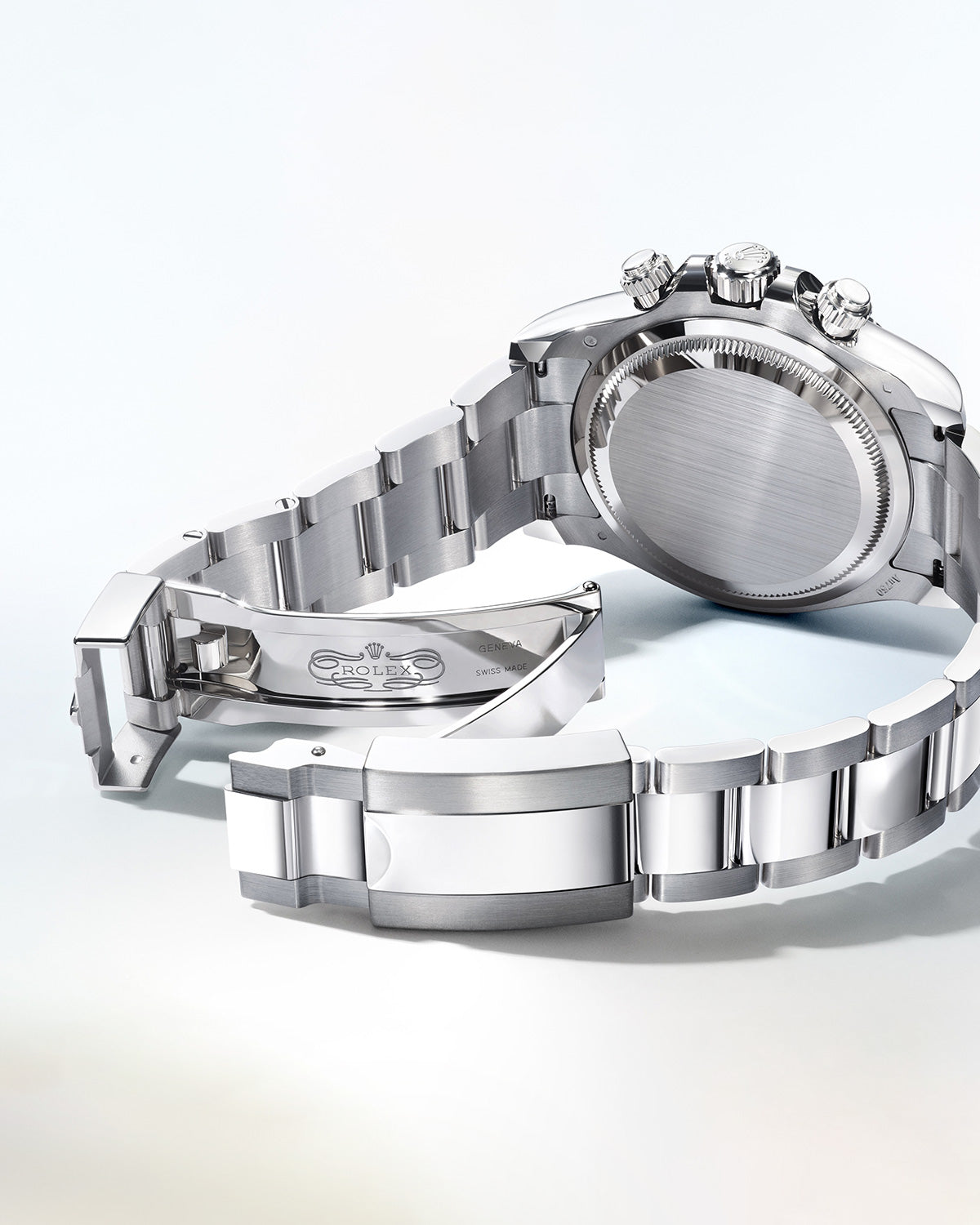 Eine Rolex-Uhr mit Edelstahlarmband wird von hinten gezeigt, wobei die polierten Glieder und der Verschluss hervorgehoben werden. Das Zifferblatt ist nicht sichtbar, nur Gehäuse und Armband sind vor einem hellen Hintergrund im Fokus.