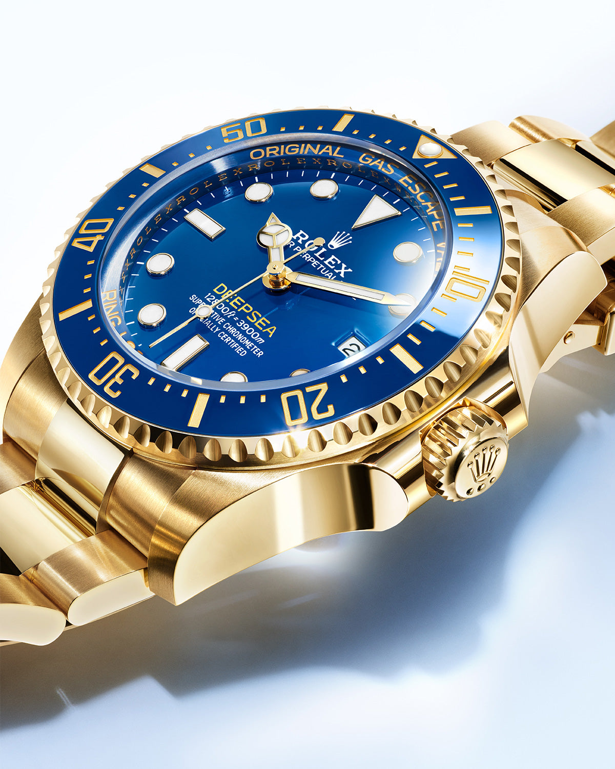 Nahaufnahme einer goldenen Luxus-Taucheruhr mit blauem Zifferblatt. Die Lünette ist für die verstrichene Zeit markiert und das Zifferblatt verfügt über leuchtende Markierungen und Zeiger. Die Uhr hat ein robustes Armband und zeigt auf dem Zifferblatt komplizierte Details.