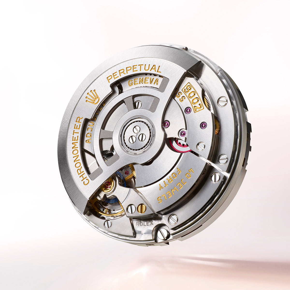 Nahaufnahme eines mechanischen Uhrwerks, das komplizierte Zahnräder und Komponenten zeigt. In die Metallteile sind Texte eingraviert, darunter „PERPETUAL“ und „GENEVA“. Das Design ist detailliert und poliert und steht vor einem hellen Hintergrund.