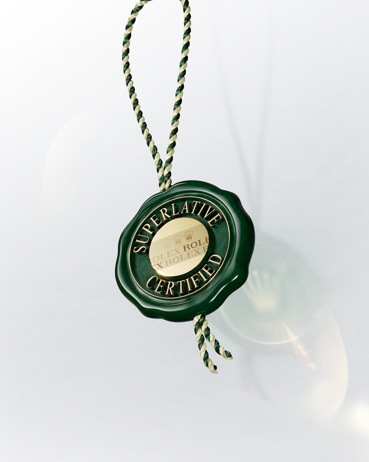 Bild eines grünen Rolex-Siegels mit dem Text „Superlative Certified“, befestigt an einer gedrehten grün-goldenen Kordel, vor einem hellen Hintergrund.
