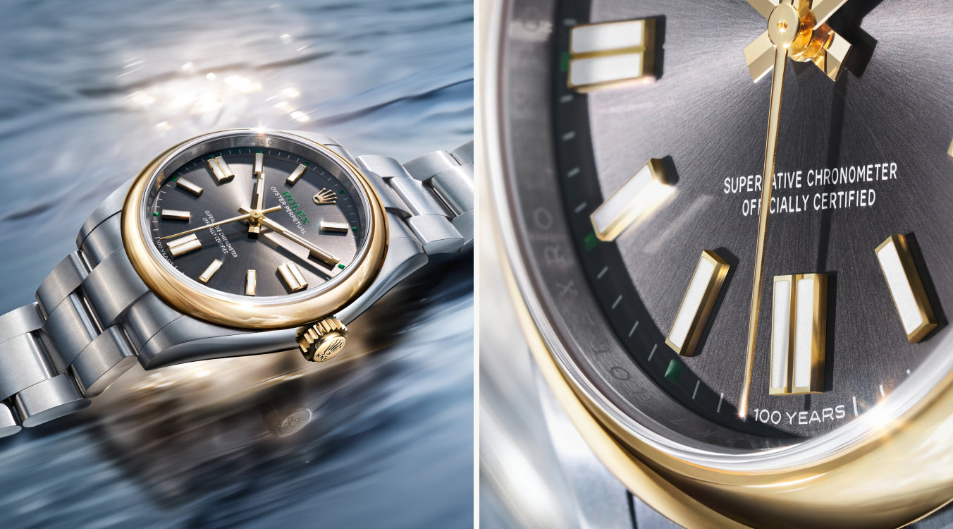 Eine luxuriöse Armbanduhr mit silbernem und goldenem Band, dunkelgrauem Zifferblatt und goldenen Indexen, dargestellt in zwei Ansichten: schräg auf einer spiegelnden Oberfläche und in einer Nahaufnahme, die das Zifferblatt und den Text "SUPERLATIVE CHRONOMETER" hervorhebt.