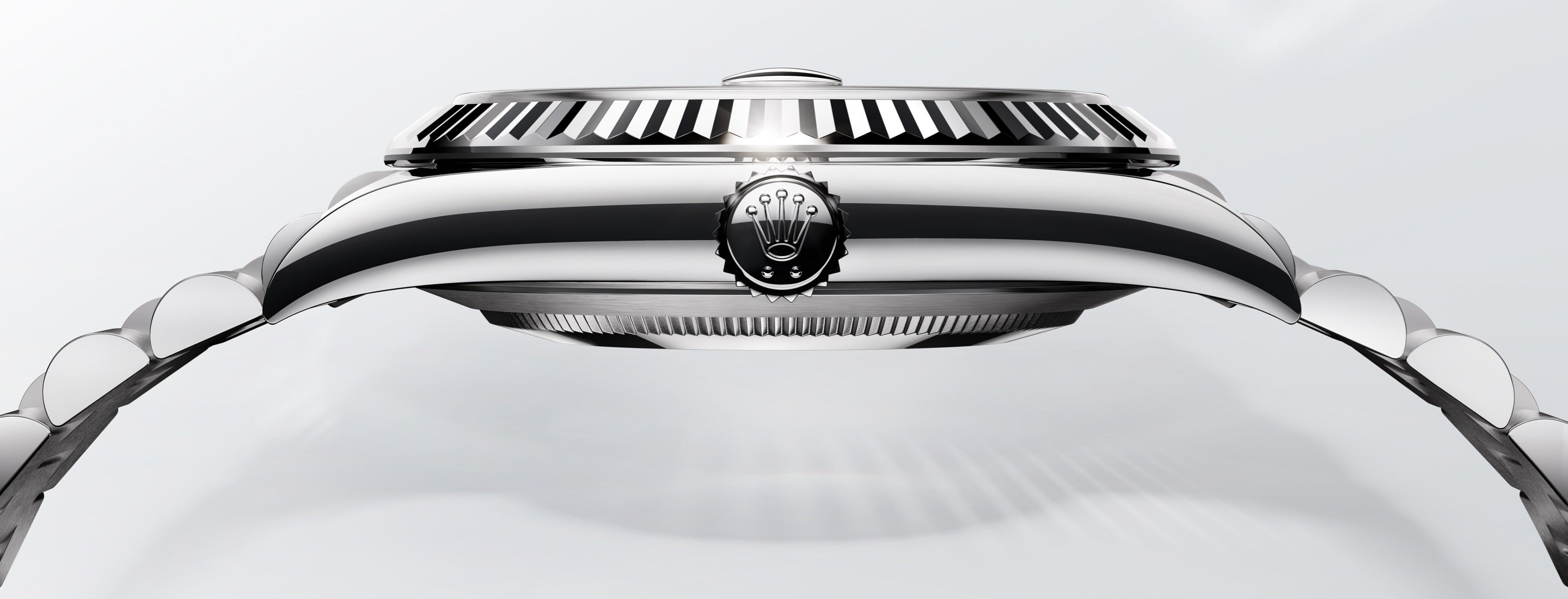 Nahaufnahme einer Luxusarmbanduhr mit poliertem Silberfinish von der Seite. Die Uhr verfügt über eine detaillierte Lünette und ein markantes Logo in der Mitte. Das Armband ist teilweise sichtbar und zeigt seine metallischen Glieder.