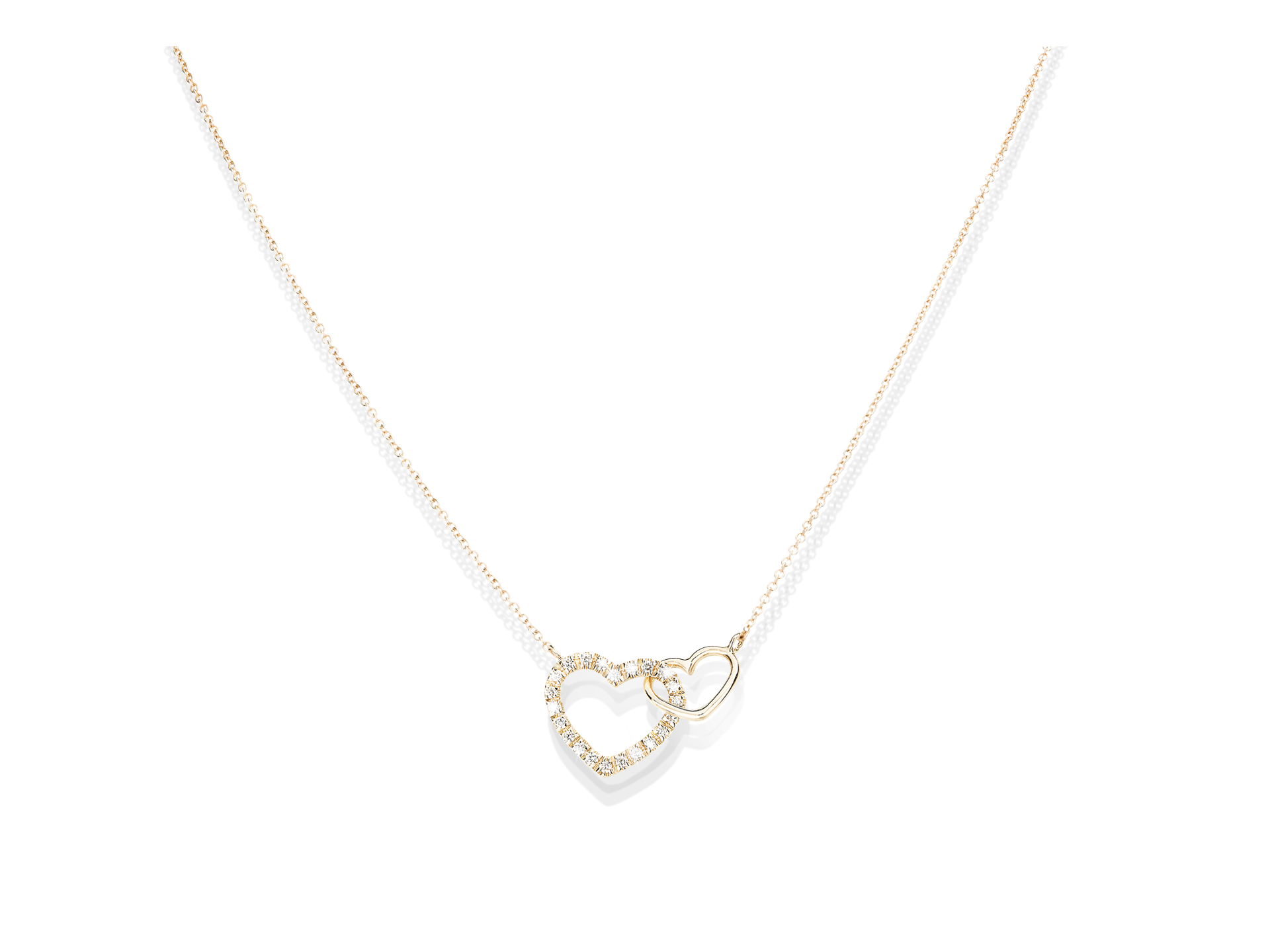 Die DIAMANT HALSKETTE HEARTS von Schullin ist ein zartes Goldcollier mit zwei ineinandergreifenden Herzanhängern - einer schlicht, der andere mit funkelnden Steinen verziert -, die elegant auf einem weißen Hintergrund präsentiert werden.