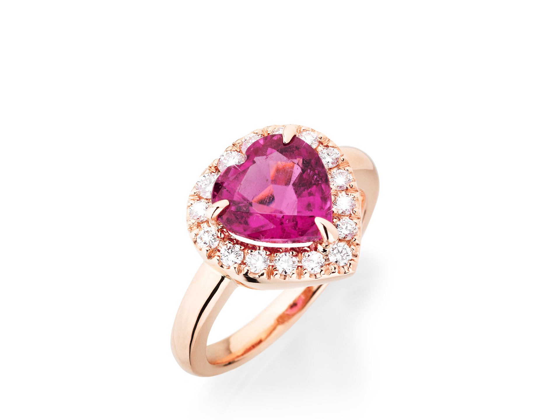 Der HERZ RING CARMOISIERT von Schullin zeigt in der Mitte einen rosafarbenen Edelstein in Herzform, der von einem Kranz weißer Diamanten umgeben ist. Er ist in Gold gefasst und steht auf einem schlichten weißen Hintergrund.