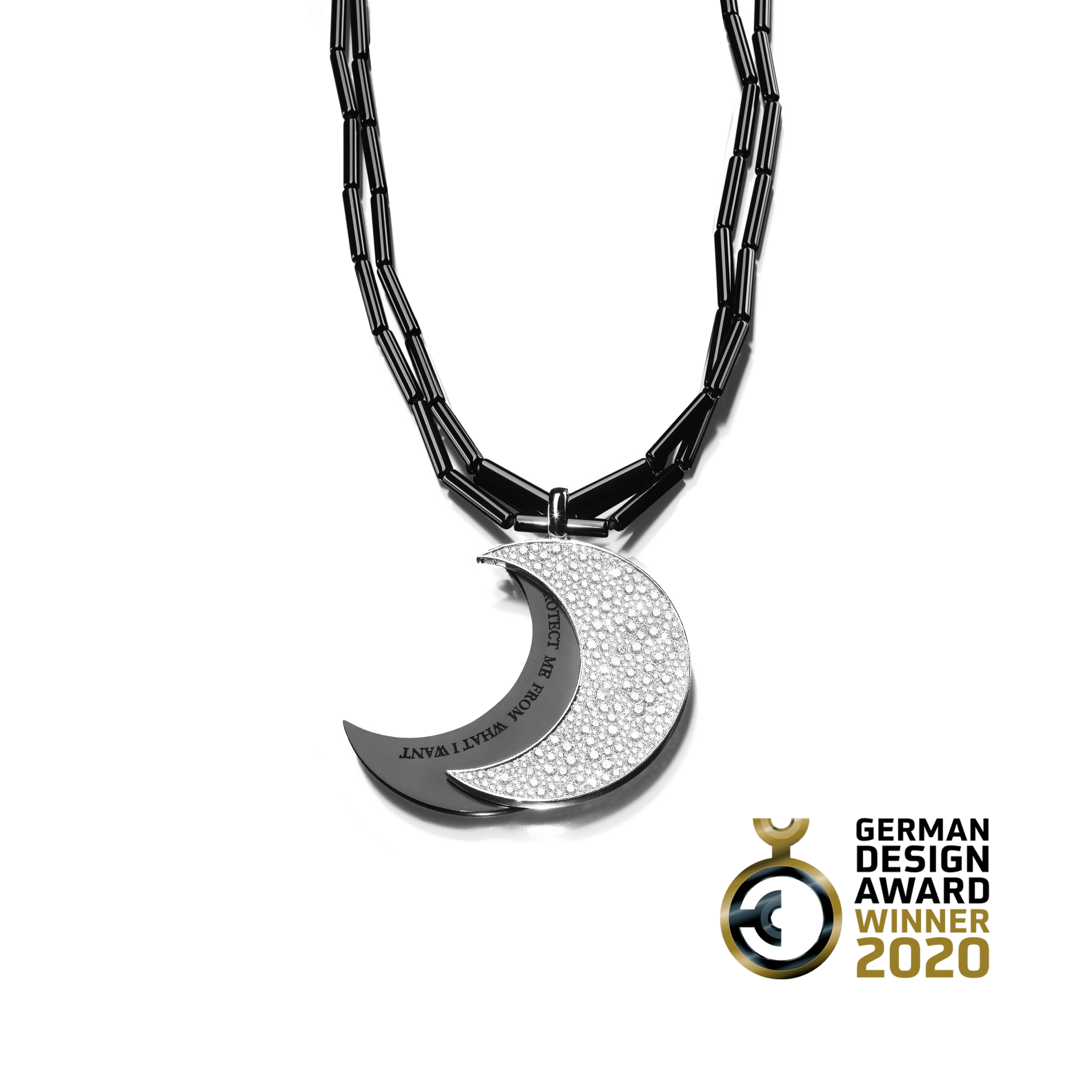 Die HALSKETTE SPIRIT von Schullin besteht aus einem silbernen Halbmondanhänger mit strukturiertem Muster und Onyx-Akzent, der elegant an einer dunklen Kette hängt. Die Rückseite der Halskette ist mit einem Text beschriftet.
