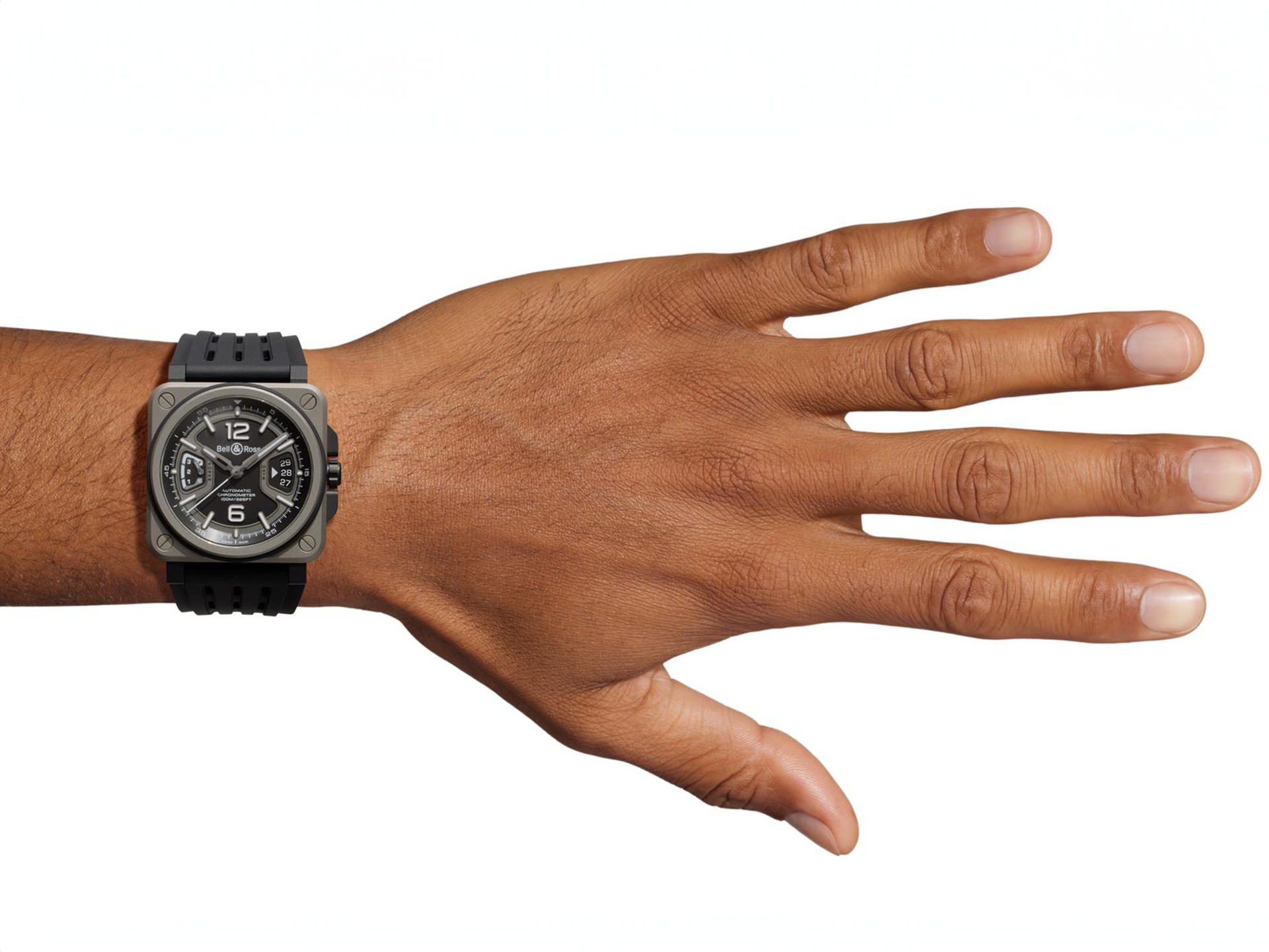 Eine Hand mit ausgestreckten Fingern zeigt die Schullin BELL & ROSS BR-X3 BLACK TITANIUM, eine schwarze, quadratische Armbanduhr mit schwarzem Kautschukband und sichtbaren Ziffern auf weißem Hintergrund.