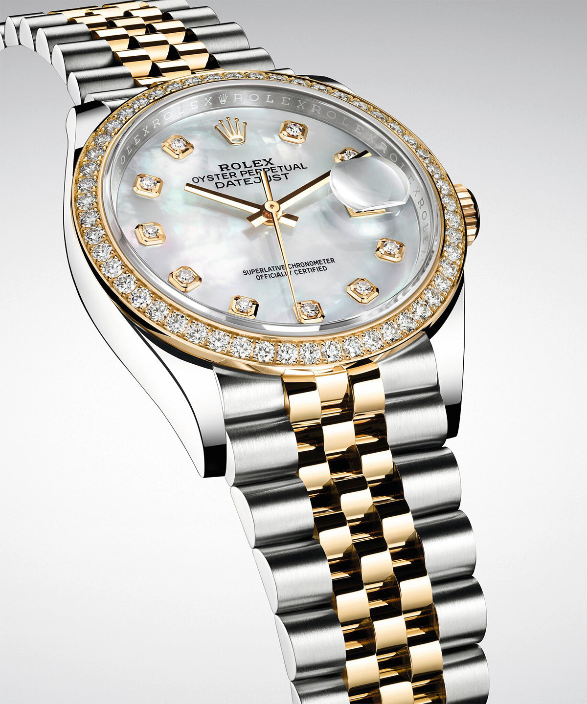 Nahaufnahme einer Rolex Oyster Perpetual Datejust mit zweifarbigem Gold- und Silberarmband, einer diamantbesetzten Lünette und einem Perlmuttzifferblatt mit Diamantindexen.