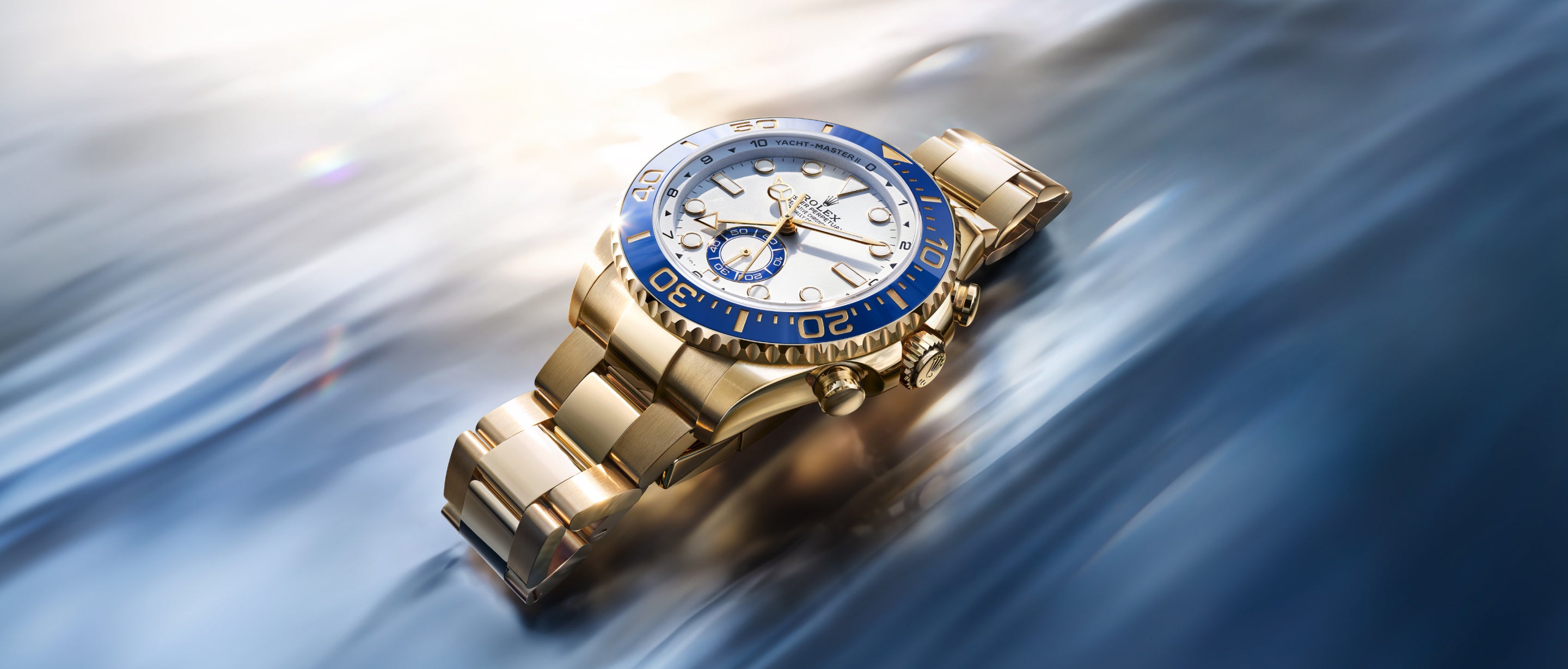 Eine goldene Armbanduhr mit blau-weißer Lünette und blau-weißem Zifferblatt auf einem unscharfen, blau-weiß glänzenden Hintergrund, der einen luxuriösen und eleganten Effekt erzeugt.